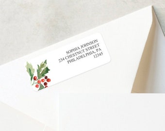 Puede incluir: Sobres blancos con etiquetas de dirección con diseños de acuarela de acebo y bayas. Las etiquetas incluyen nombres y direcciones. También hay sellos decorativos y una cinta roja. El texto "CREATIVE UNION DESIGN" está en la parte inferior.