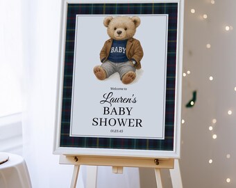 Könnte beinhalten: Ein weiß gerahmtes Schild auf einer Staffelei mit einem karierten Rand. Auf dem Schild steht "Willkommen zu Laurens Babyparty" mit einer Teddybär-Illustration, die einen Pullover mit der Aufschrift "Baby" trägt.
