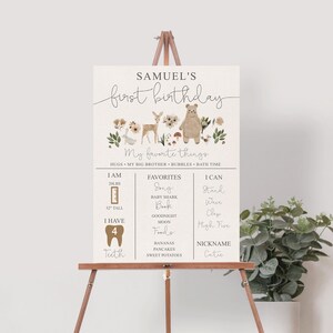 May include: A brown and beige printable first birthday sign with a woodland theme. The sign features a bear, deer, and rabbit. It includes the name "Samuel's first birthday" and details about the child's age, height, weight, favorite things, and abilities.