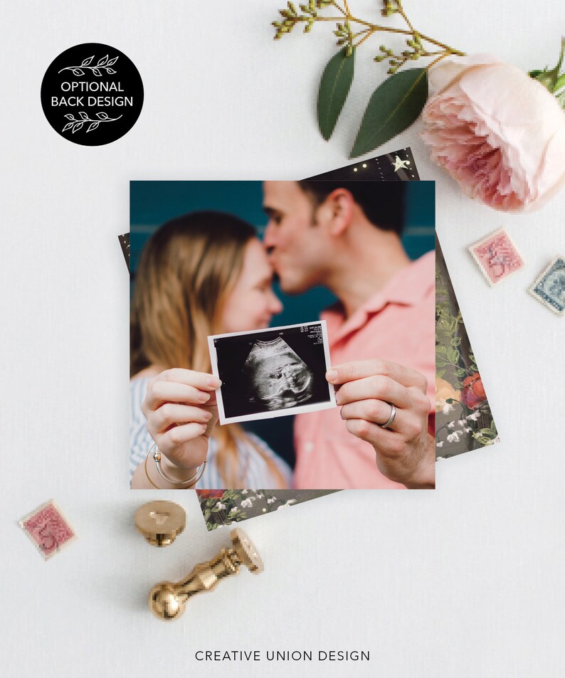 May include: A couple holds an ultrasound image of their baby in front of a teal background. The image is in a white frame and shows a baby in the womb. The couple is smiling and looking at the image. The image is surrounded by a floral pattern.