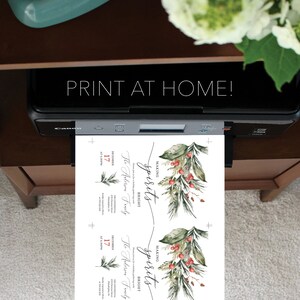 Pu&ograve; includere: Una stampante stampa due inviti per le vacanze con la scritta &laquo;STAMPA A CASA!&raquo;. Gli inviti presentano illustrazioni ad acquerello di vegetazione e bacche, con le parole &laquo;MAKING SPIRITS BRIGHT&raquo;.