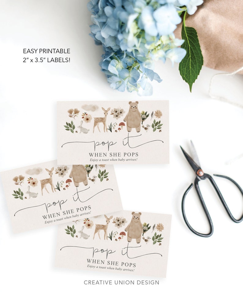 Puede incluir: Tres etiquetas imprimibles de 5 x 8,9 cm con un tema de bosque. Cada etiqueta presenta un oso marr&oacute;n, un ciervo y otras criaturas del bosque con el texto "pop it when she pops enjoy a toast when baby arrives!" y el texto "CREATIVE UNION DESIGN".
