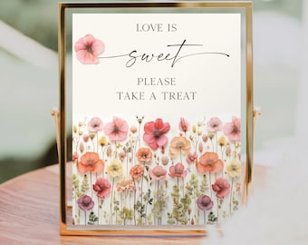May include: A printable sign with a floral design and the text "Love is sweet. Please take a treat." The sign is in a gold frame and is sitting on a wooden surface.