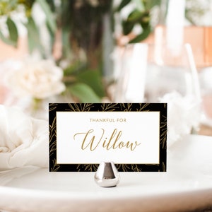 Puede incluir: Una tarjeta de lugar negra y dorada con un borde blanco y el texto "Thankful for Willow".
