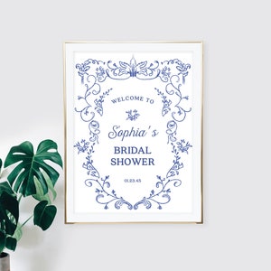 May include: A white printable sign with a blue floral border and the text "Welcome to Sophia's Bridal Shower 01.23.45".