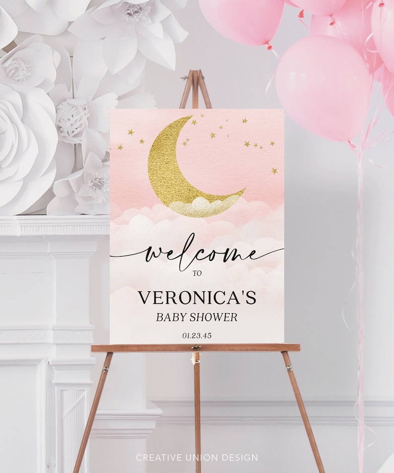 May include: A rectangular welcome sign for a baby shower featuring a gold glitter crescent moon, small gold stars, and soft pink clouds. The text reads: welcome TO VERONICA'S BABY SHOWER 01.23.45. The sign is displayed on a wooden easel.