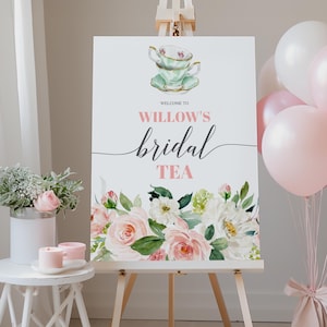 Peut inclure: Panneau blanc sur chevalet avec l'inscription « Welcome to Willow's Bridal Tea ». Le panneau présente une illustration à l'aquarelle d'une tasse et d'une soucoupe, et un arrangement floral de roses roses et blanches.