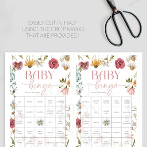 May include: A printable baby bingo card with a floral design. The card has a pink title that says "Baby Bingo" and has a grid of 25 squares with various baby-related items listed in each square. The squares are surrounded by a floral border.