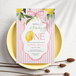 Könnte beinhalten: Eine Geburtstagseinladung mit rosa und weißen Streifen. Die Einladung zeigt ein Aquarell-Zitronen-Design und den Text "Sophia is turning ONE". Die Einladung liegt auf einem gelben Teller mit dekorativen Stielen.