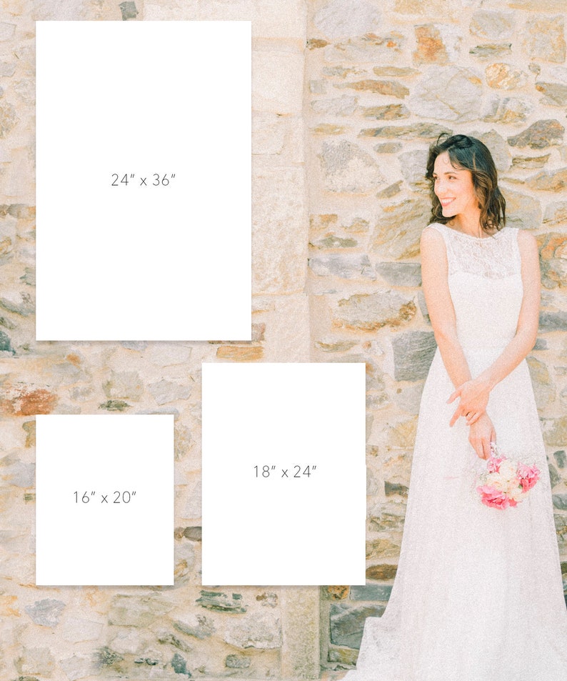 May include: Three white frames with black text indicating different sizes: 24" x 36", 18" x 24", and 16" x 20". The frames are against a stone wall. A woman in a white dress is standing to the right of the frames.