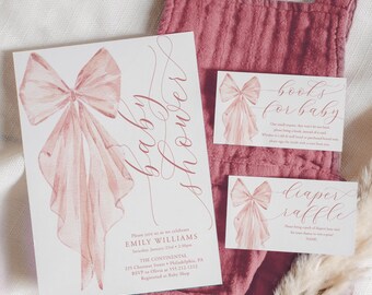 May include: A pink and white baby shower invitation with a watercolor bow and the text "baby shower". There are also two smaller cards with the text "books for baby" and "diaper raffle".