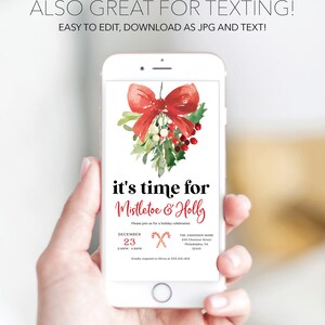 Op de afbeelding: Een smartphone toont een kerstuitnodiging met een rood strikje, maretak en hulst. De tekst luidt "it's time for Mistletoe & Holly" met evenementdetails. De telefoon wordt in een hand gehouden.