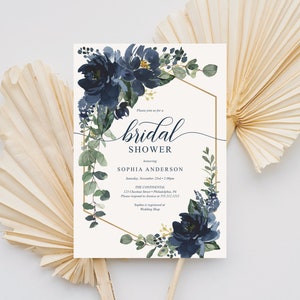 Op de afbeelding: Uitnodiging voor een bruidsdouche met marineblauw bloemen aquarelontwerp. De uitnodiging bevat de tekst "bridal shower" in elegant schrift, samen met evenementdetails en de namen van de bruid en gastheer. De uitnodiging is omlijst door een gouden geometrische rand.