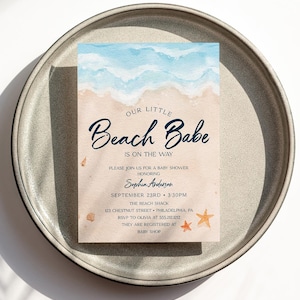 May include: A baby shower invitation with a watercolor beach scene. The text reads "Our Little Beach Babe is on the way." The invitation includes the date, time, location, and RSVP information.
