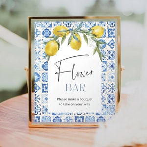 Puede incluir: Un cartel con un fondo de azulejos azules y blancos y una rama de limón con limones amarillos. El cartel dice "Flower Bar" y "Por favor, haz un ramo para llevarte".