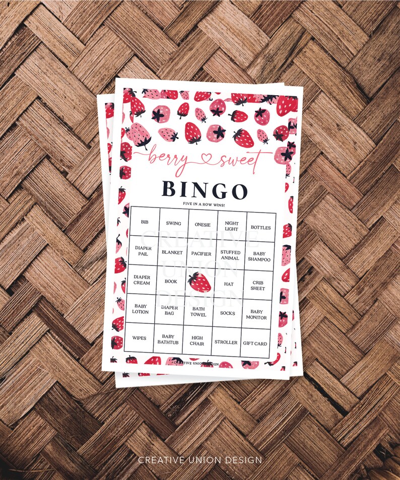 May include: A pink and white bingo card with a strawberry pattern. The card has a title that says "berry & sweet BINGO" and has a list of baby items in each square. The text "FIVE IN A ROW WINS!" is at the top of the card.