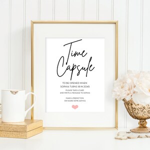 May include: A framed sign with the text "Time Capsule" and instructions to be opened when Sophia turns 18 in 2045. The sign instructs guests to take a card and write a message to Sophia, make a prediction, or share some advice.