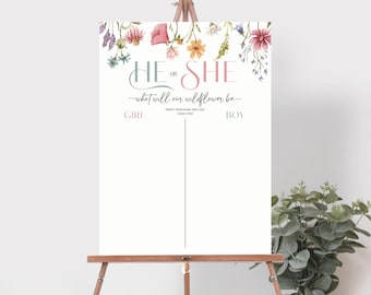 May include: A gender reveal party sign with a floral border. The sign says "He or She - what will our wildflower be?" with a line down the middle for guests to write their guesses. The sign is on an easel.