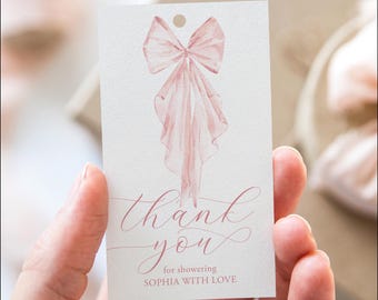 May include: A white thank you tag with a pink watercolor bow and the text "thank you for showering Sophia with love".