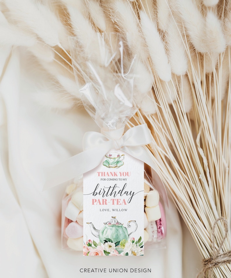 May include: A pink and green thank you tag with a teacup and teapot design. The tag says "Thank you for coming to my birthday par-tea. Love, Willow."  The tag is attached to a clear cellophane bag filled with marshmallows and macarons.