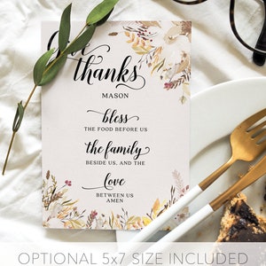 May include: A white card with the words "Give thanks" in elegant script, floral accents, and the text "Mason". The card includes the phrases "bless the food before us", "the family beside us, and the love between us, amen". The text "Optional 5x7 size included" is at the bottom.