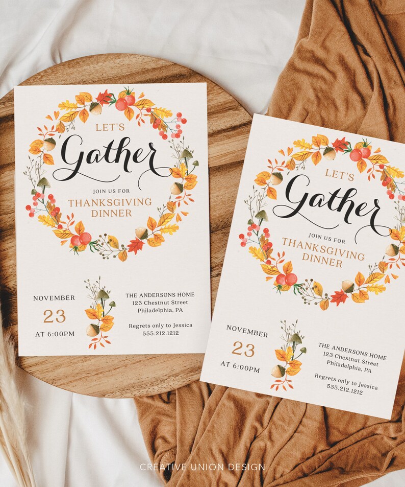 K&ouml;nnte beinhalten: Zwei Thanksgiving-Dinner-Einladungen mit einem Aquarell-Kranz-Design. Die Einladungen lauten "Let's Gather" und enthalten Datum, Uhrzeit und Adresse. Der Kranz zeigt Herbstbl&auml;tter, Beeren und Eicheln. Die Einladungen liegen auf einem Holztablett.