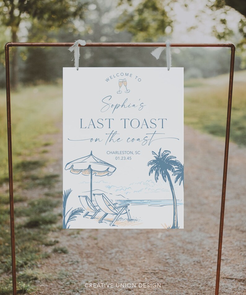 May include: A white sign with blue text that says "Welcome to Sophia's Last Toast on the Coast" with a drawing of a beach scene with palm trees, beach chairs, and an umbrella. The sign also includes the text "Charleston, SC 01.23.45" and "Creative Union Design".
