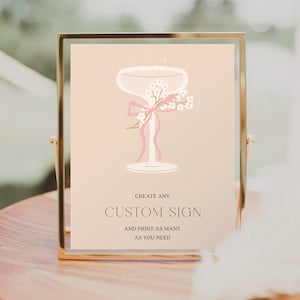 May include: A printable sign with a champagne glass illustration and pink ribbon. The text reads "Create any Custom Sign and print as many as you need." Below the text is "Creative Union Design."