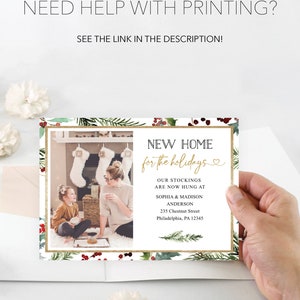 May include: A holiday-themed card with a photo of a family in front of a fireplace. The card features text that reads "New Home for the Holidays" and includes the family's names and address. The card is decorated with festive greenery.