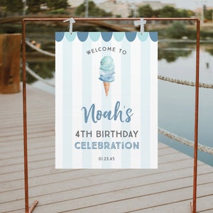 May include: Welcome to Noah's 4th Birthday Celebration sign with a blue and white striped background and a watercolor illustration of an ice cream cone with blue and green ice cream. The sign is hanging on a copper stand.
