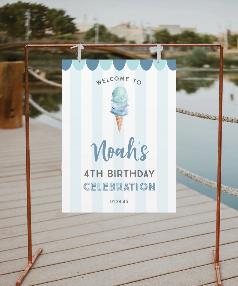 May include: Welcome to Noah's 4th Birthday Celebration sign with a blue and white striped background and a watercolor illustration of an ice cream cone with blue and green ice cream. The sign is hanging on a copper stand.
