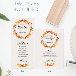 May include: Two printable Thanksgiving place cards with a fall-themed wreath design. The text reads "So very thankful for you Mason" and "Bless the food before us, the family beside us, and the love between us. Amen". The cards are available in two sizes: 4x9 inches and 5x7 inches.