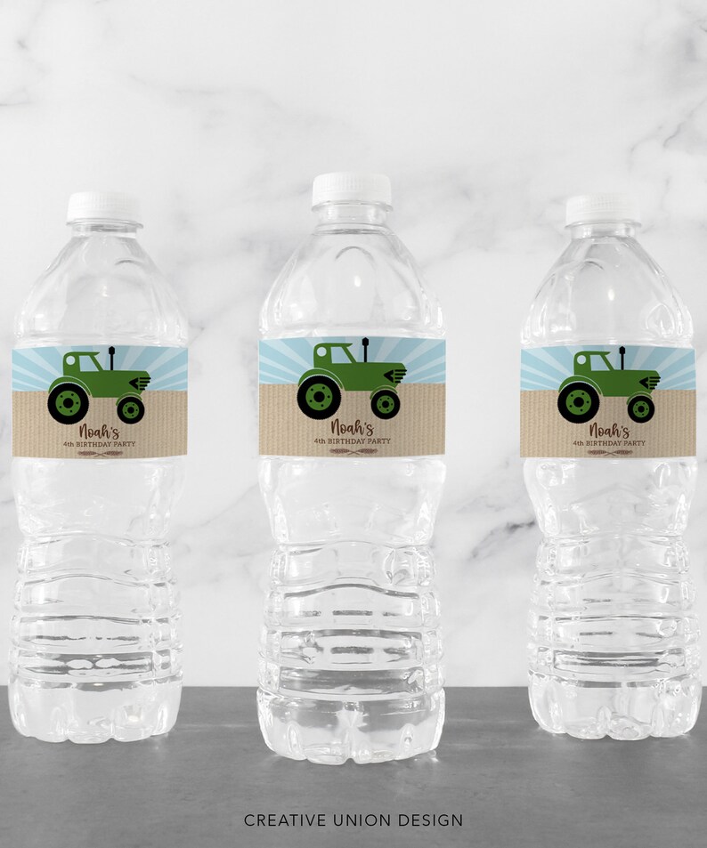May include: Three clear plastic water bottles with white caps. Each bottle has a label featuring a green tractor illustration on a tan background with blue rays. The text on the label reads "Noah's 4th Birthday Party".