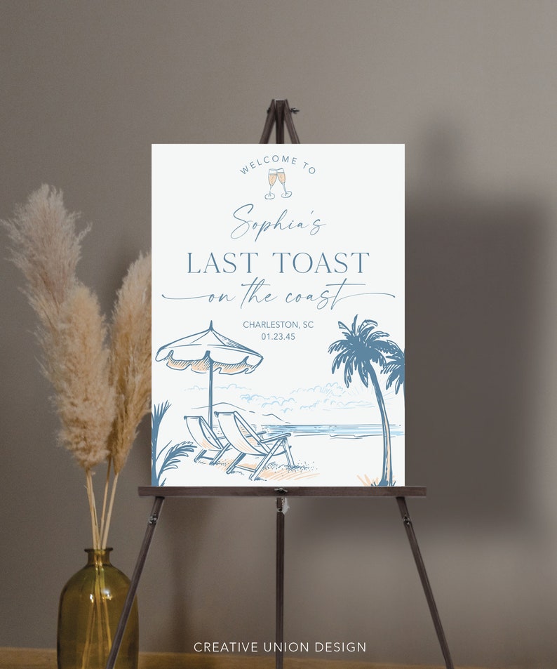 May include: A white welcome sign with blue and orange illustrations of a beach scene, palm trees, and deckchairs. The text reads "Welcome to Sophia's Last Toast on the Coast, Charleston, SC 01.23.45".