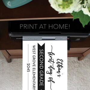May include: A black Canon printer outputting a white sheet of paper with black text that reads: Ethan's first day of SECOND GRADE WEST GROVE ELEMENTARY 2045. The text PRINT AT HOME is visible above the printer, and the brand name Creative Union Design appears.