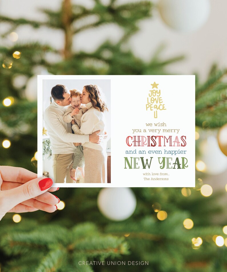 May include: A rectangular holiday greeting card featuring a photograph of two adults embracing a child on the left side. The right side displays a gold star, the text JOY LOVE PEACE, and the message we wish you a very merry CHRISTMAS and an even happier NEW YEAR with love from, The Andersons.