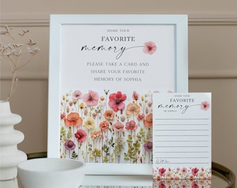 Puede incluir: Marco blanco con un cartel que dice "Comparte tu recuerdo favorito. Por favor, toma una tarjeta y comparte tu recuerdo favorito de Sophia."  El marco tiene un estampado floral con flores rosas, naranjas y amarillas.  Una tarjeta más pequeña con el mismo estampado floral dice "Comparte tu recuerdo favorito de Sophia."  La tarjeta tiene líneas para escribir.