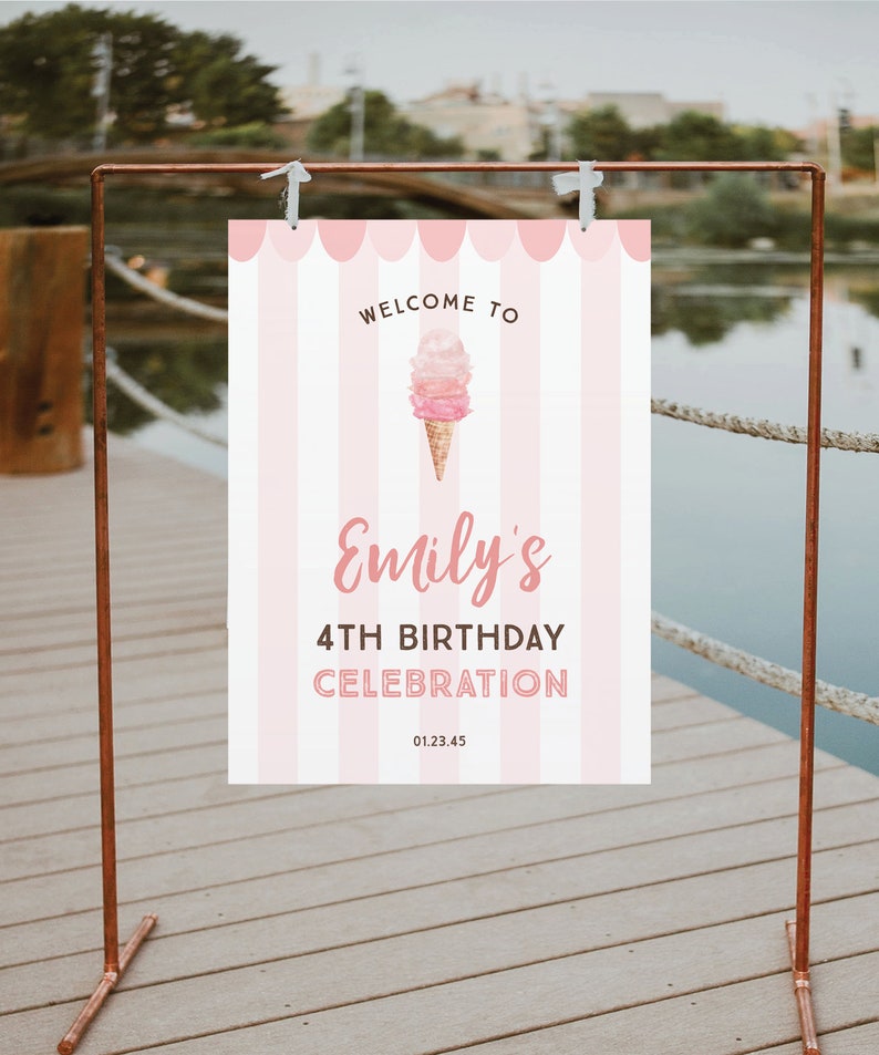 May include: A pink and white striped sign with the text "Welcome to Emily's 4th Birthday Celebration" and an ice cream cone graphic. The sign is hanging from a copper-colored metal frame, perfect for a birthday party.