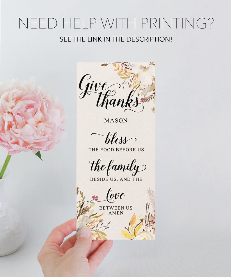 May include: A rectangular card with the words "Give thanks" in elegant script, surrounded by floral accents. The card includes the text "bless the food before us, the family beside us, and the love between us, amen."