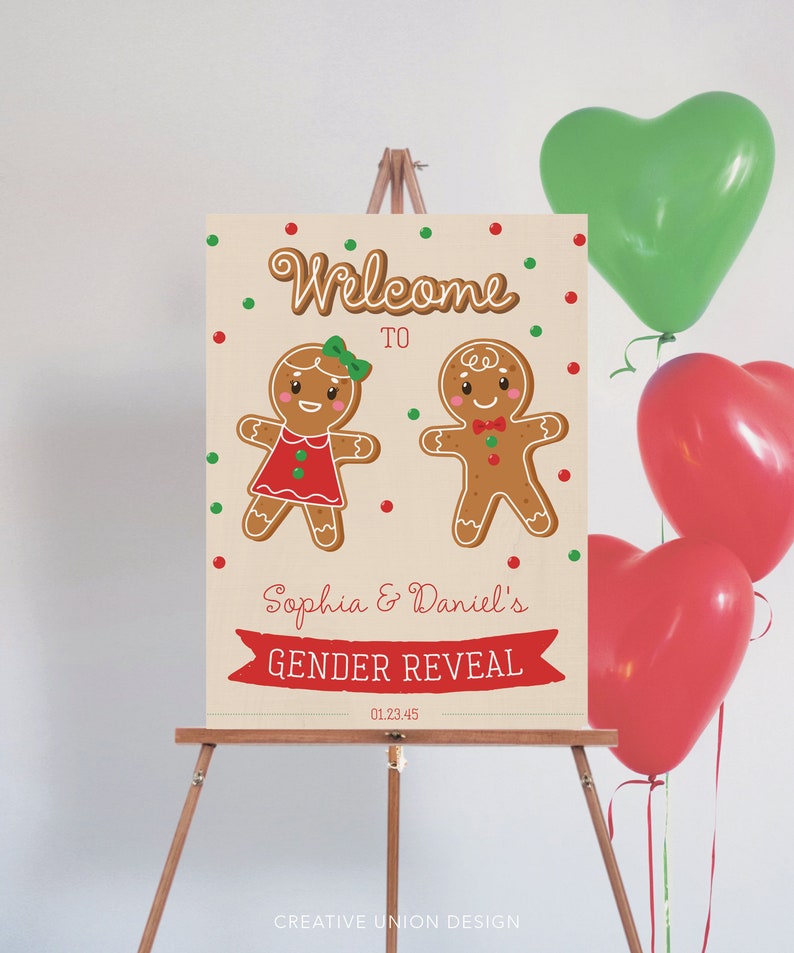 May include: A gender reveal sign on an easel features gingerbread people and the text "Welcome to Sophia & Daniel's Gender Reveal." Red and green heart-shaped balloons are in the background. The sign is decorated with red and green dots.