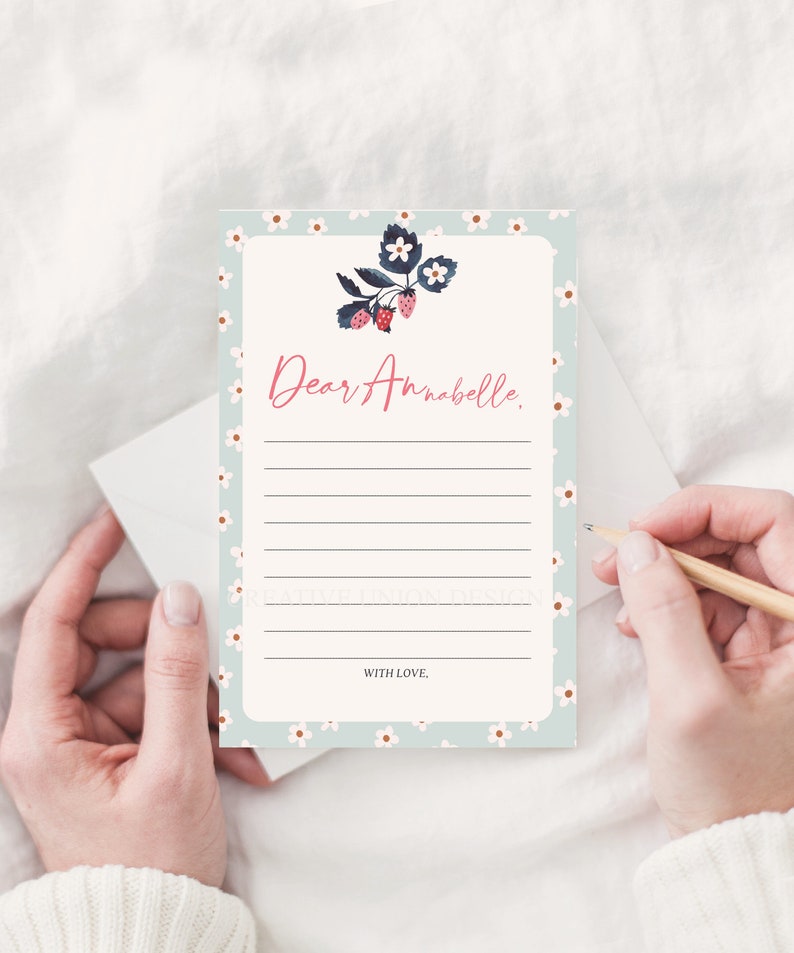 May include: A light blue stationery card with a white floral pattern and a strawberry illustration. The card has lines for writing and says "Dear Annabelle." at the top and "With Love." at the bottom.