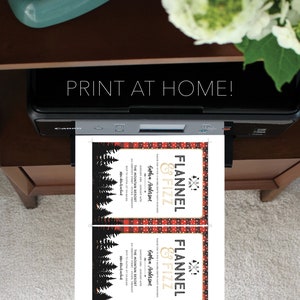 K&ouml;nnte beinhalten: Ein Drucker druckt zwei Einladungen mit dem Text "Flannel & Fizz" und "Print at Home!". Die Einladungen haben einen rot-schwarzen Karomuster-Rand mit einem Waldsilhouetten-Design. Die Einladungen sind f&uuml;r einen Junggesellinnenabschied.