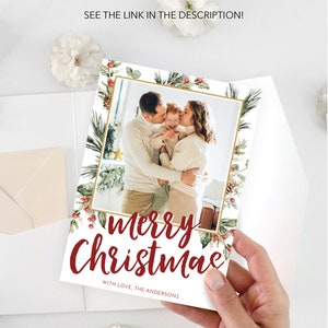May include: A Christmas card featuring a family photo within a gold frame, surrounded by festive greenery and red berries. The card reads "Merry Christmas" in a stylish script, with the family name below. The text "Need help with printing? See the link in the description!" is also visible.