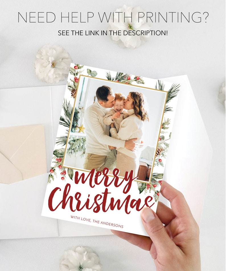 May include: A Christmas card featuring a family photo within a gold frame, surrounded by festive greenery and red berries. The card reads "Merry Christmas" in a stylish script, with the family name below. The text "Need help with printing? See the link in the description!" is also visible.