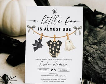 Può includere: Un invito per un baby shower con il testo "a little boo is almost due". L'invito presenta un pipistrello, un body e un fantasma appesi a un filo. L'invito è per Sophia Anderson, 28 ottobre, 14:30.