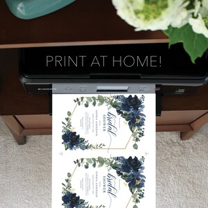 Op de afbeelding: Een printer drukt twee uitnodigingen voor een bruidsdouche af. De uitnodigingen hebben marineblauwe bloemstukken, gouden geometrische frames en de tekst "PRINT AT HOME!" en "bridal shower". Het ontwerp bevat de tekst "SOPHIA ANDERSON".