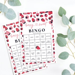 May include: Two pink and white bingo cards with a strawberry pattern. The cards have a title that says "berry sweet bingo" and list items like "bib", "swing", "onesie", "night light", "bottles", "diaper pail", "blanket", "pacifier", "stuffed animal", "baby shampoo", "diaper cream", "book", "hat", "crib sheet", "baby lotion", "diaper bag", "bath towel", "socks", "baby monitor", "wipes", "baby bathtub", "high chair", "stroller", "gift card".