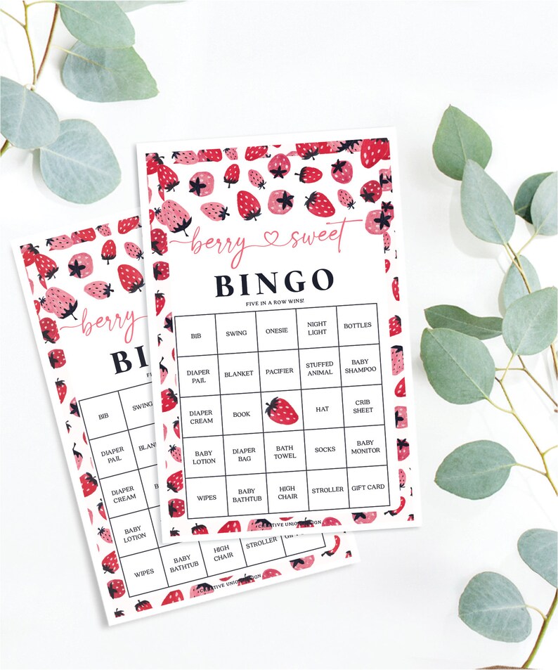 May include: Two pink and white bingo cards with a strawberry pattern. The cards have a title that says "berry sweet bingo" and list items like "bib", "swing", "onesie", "night light", "bottles", "diaper pail", "blanket", "pacifier", "stuffed animal", "baby shampoo", "diaper cream", "book", "hat", "crib sheet", "baby lotion", "diaper bag", "bath towel", "socks", "baby monitor", "wipes", "baby bathtub", "high chair", "stroller", "gift card".