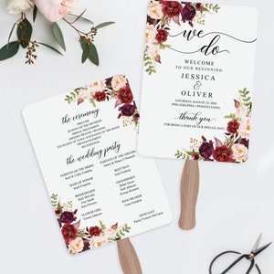 May include: Two white wedding fan programs with floral accents in burgundy, blush, and green. The fans feature event details, including the names Jessica & Oliver, ceremony order, and wedding party. The text "We Do" is at the top.