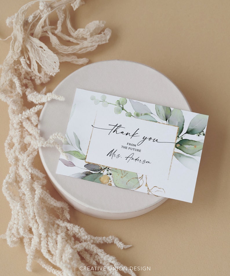 May include: A white thank you card with green watercolor leaves and gold accents. The text reads "Thank you from the future Mrs. Anderson".